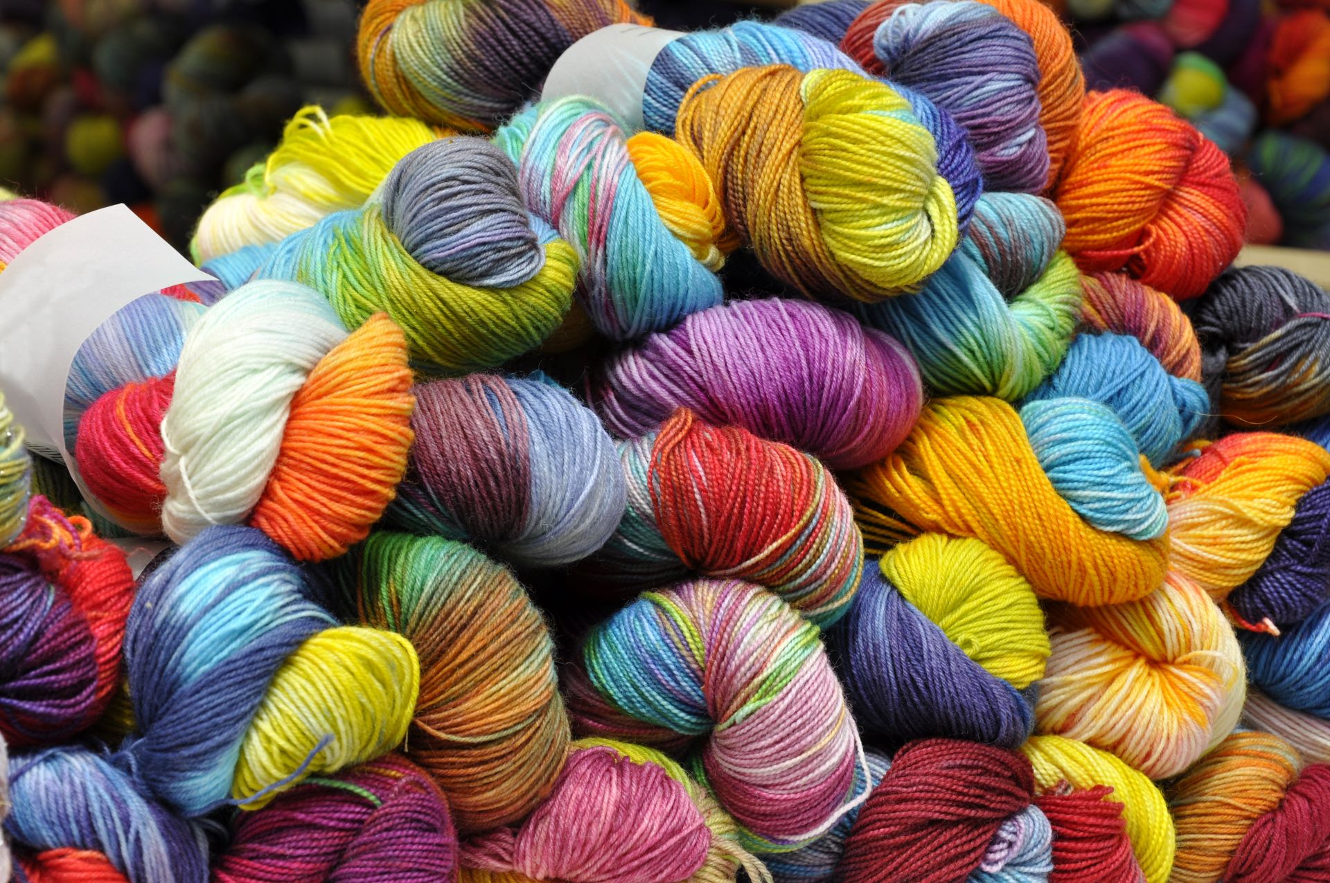 Stapel bunter Wollknäuel in leuchtenden Farben.