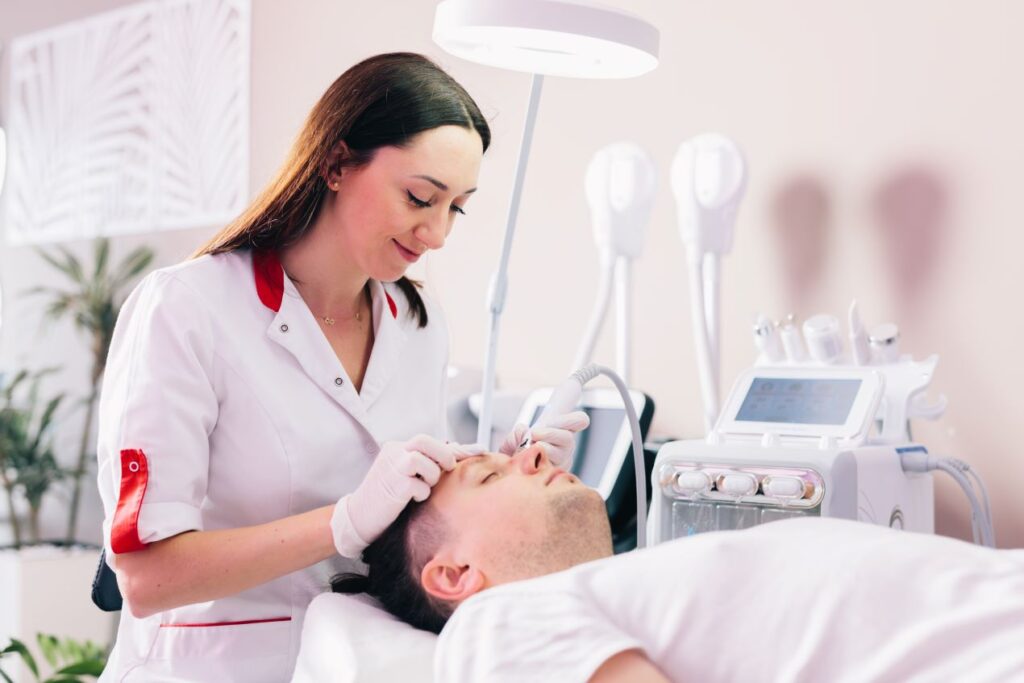 Professionelle Hydrafacial-Behandlung: Eine Kosmetikerin führt eine intensive Gesichtsreinigung und Pflege bei einem Mann durch – Symbolbild für die Vorteile einer professionellen Hydrafacial-Therapie mit modernster Technologie.